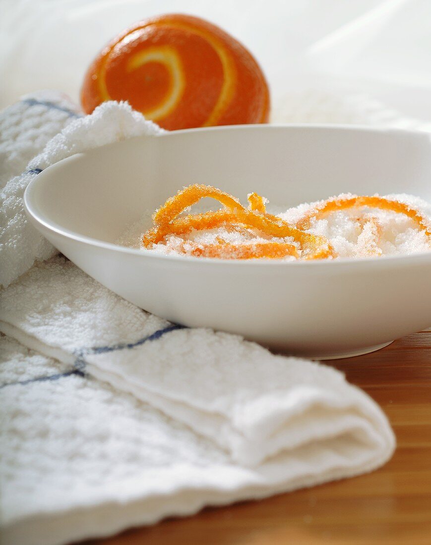 Candied Orange Zest in Bowl of Sugar; Partially Zested Orange