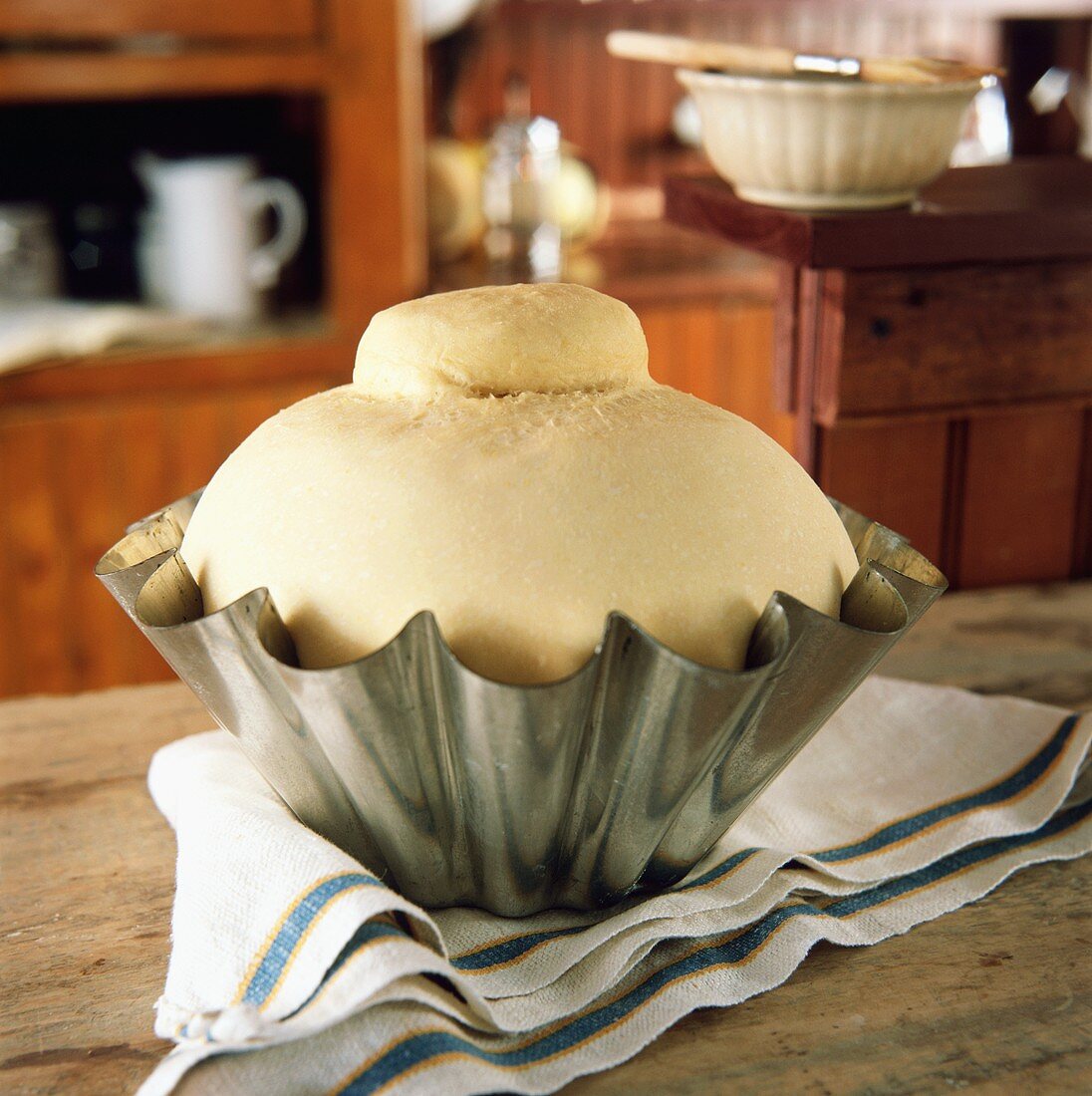 Brioche, ungebacken, in Backform in rustikaler Küche