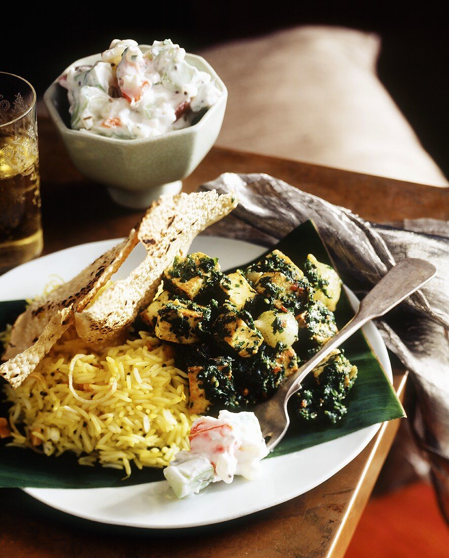 Indian side dishes: potatoes, cucumber with yoghurt, rice, naan