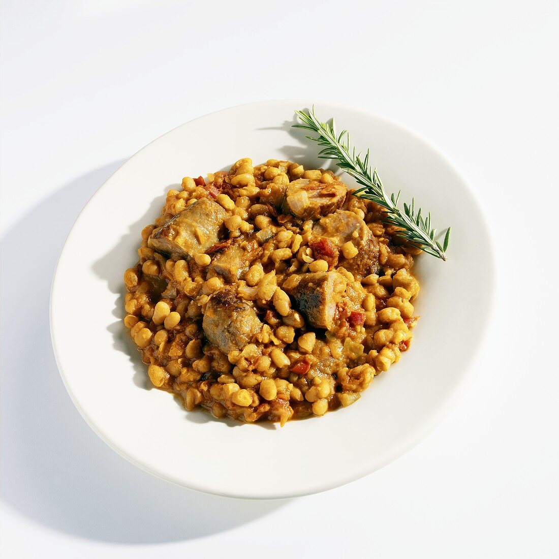 Sausage, Baked Beans and Salsa in a White Bowl with Rosemary Garnish