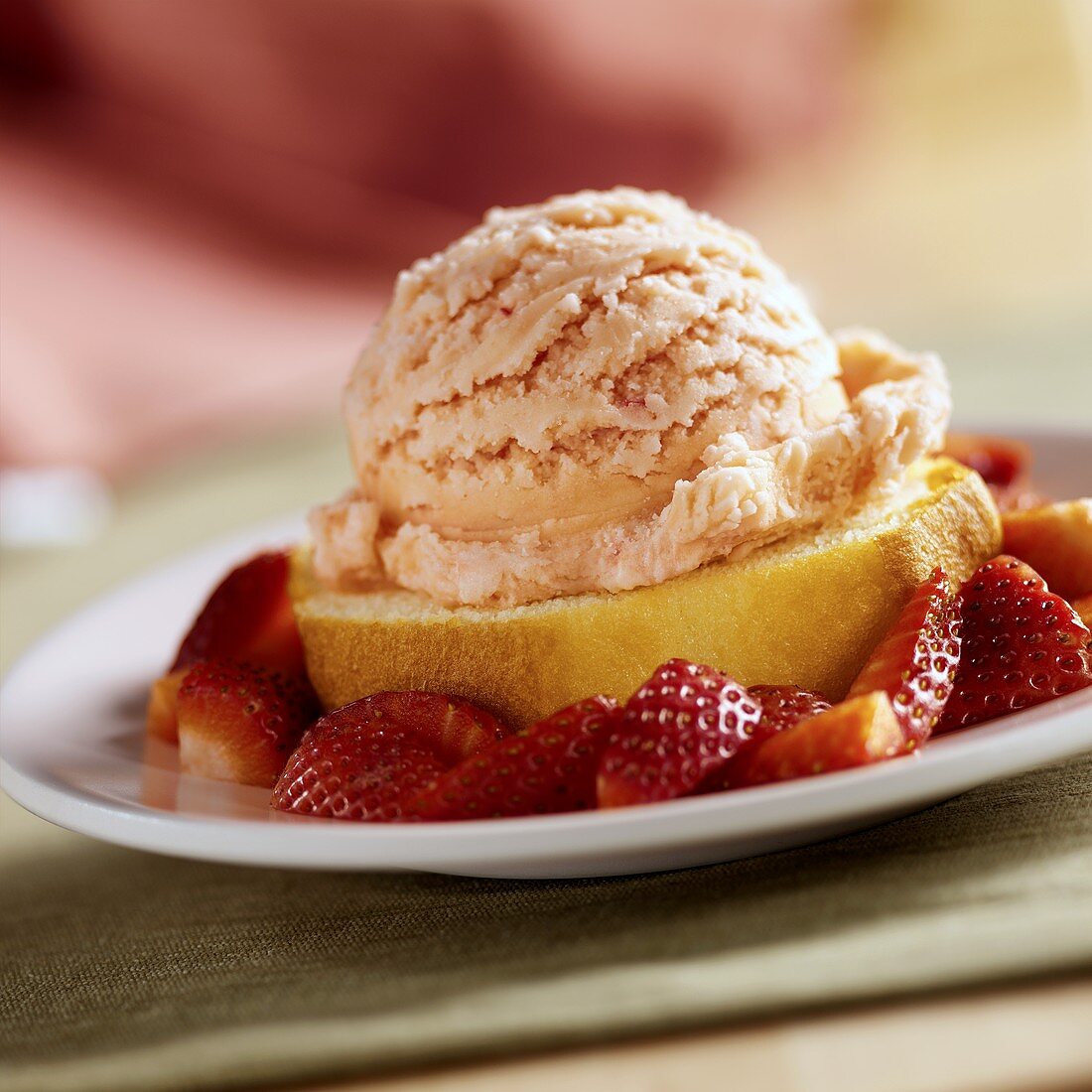 A slice of sponge cake with strawberry ice cream & fresh strawberries