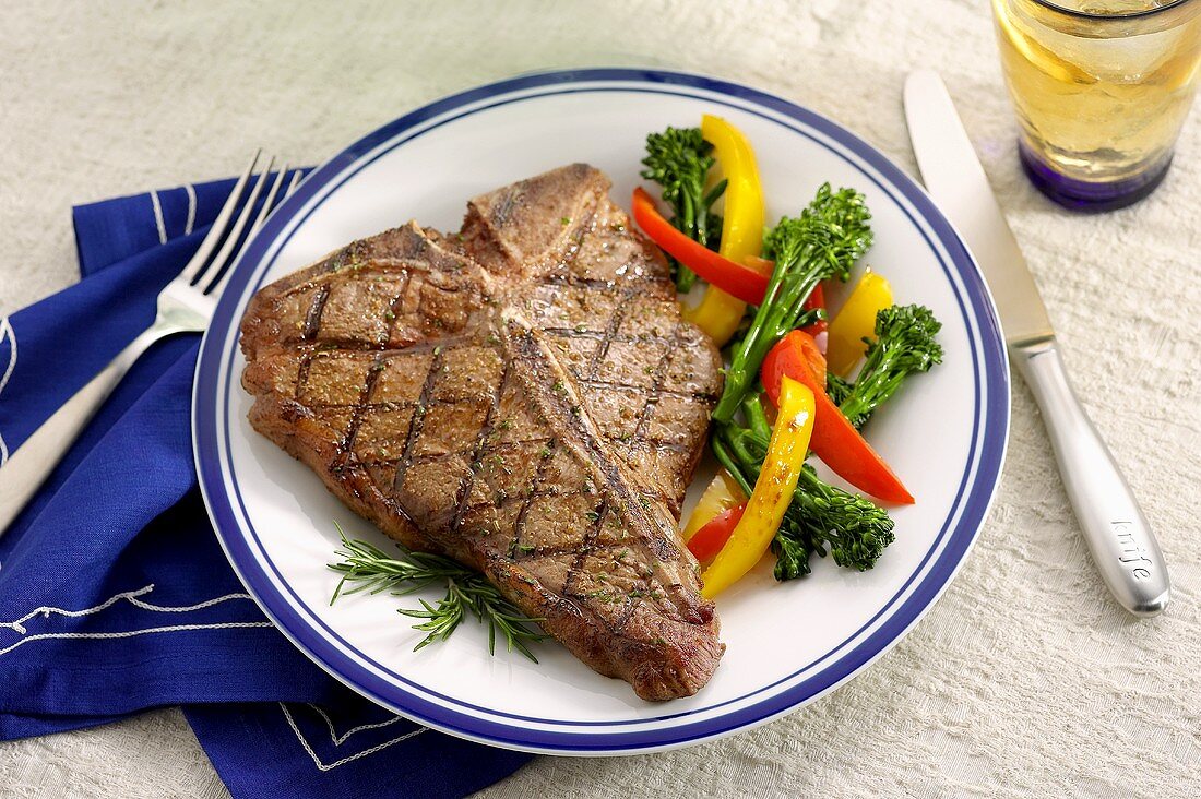 Grilled Steak Served with Bell Peppers and Broccoli Rabe, On a Plate with Flatware