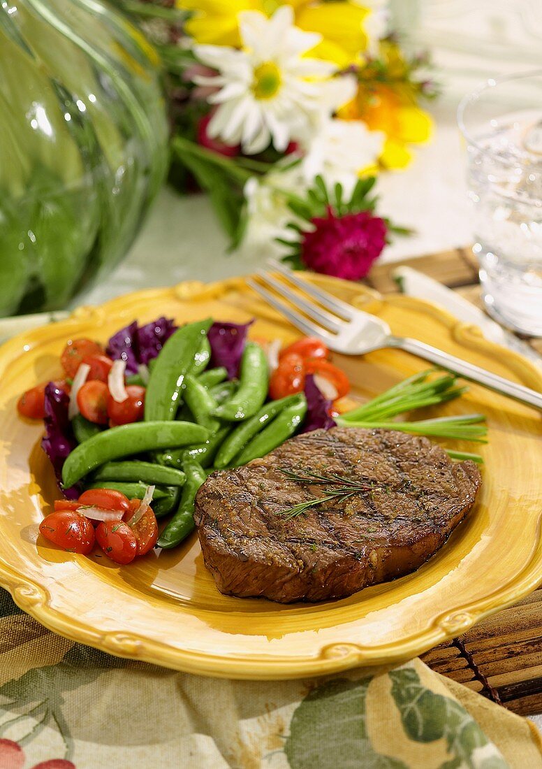 Grilled steak with sugar snap peas and tomatoes