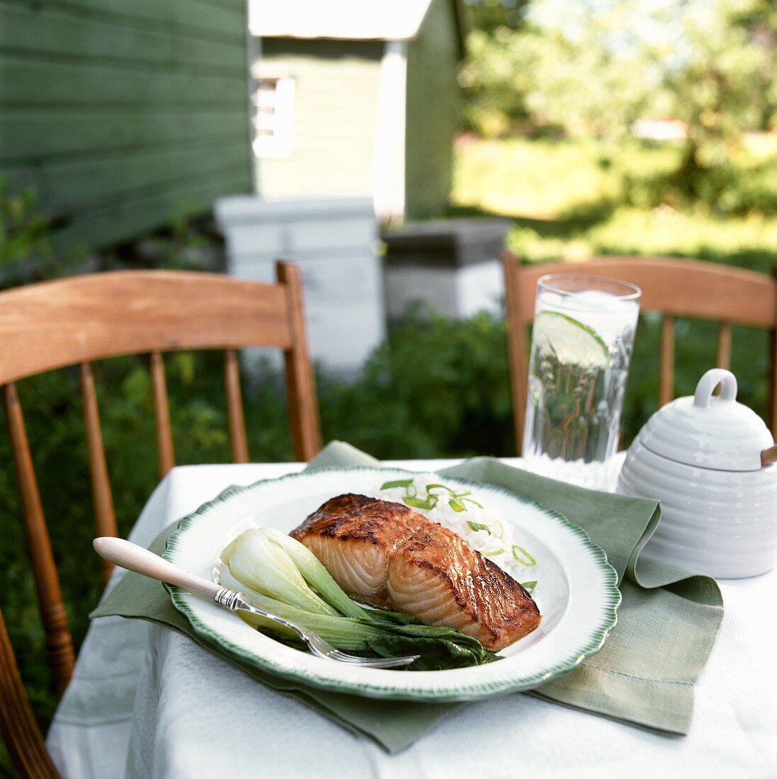 Salmon fillet with honey, pak choi & rice on outdoor table