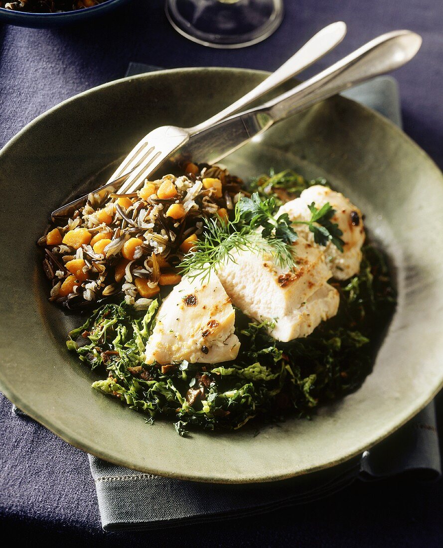 Chicken breast on leafy vegetables and wild rice