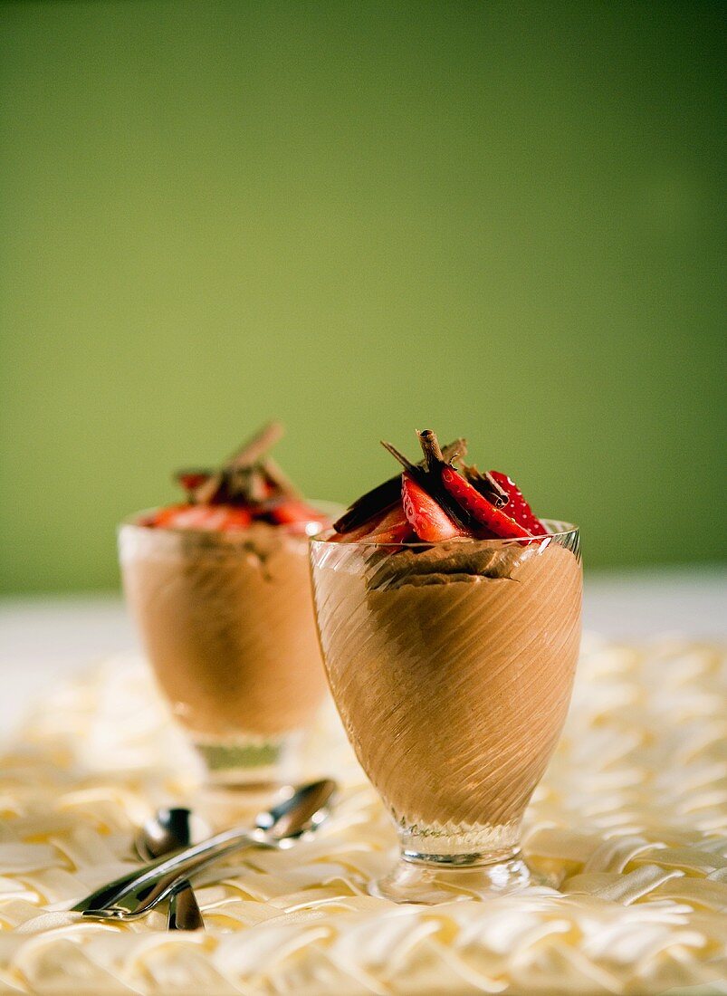 Zwei Gläser Schokoladenmousse mit Erdbeeren und Schokospänen