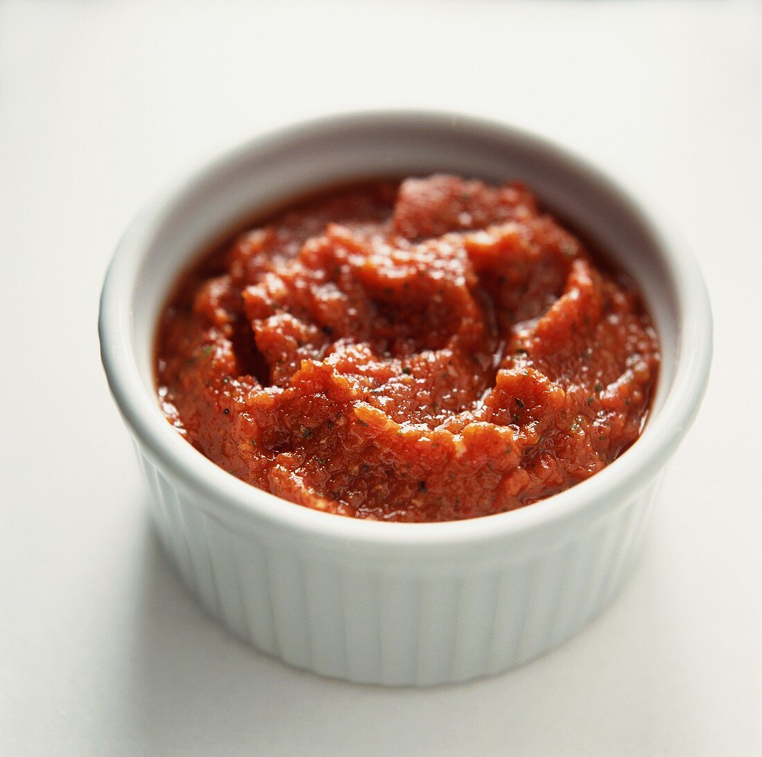 Aufstrich aus getrockneten Tomaten in weißem Schälchen