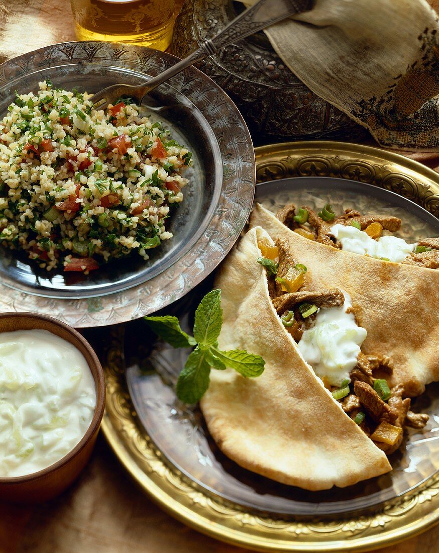 Tabouleh mit Tomaten und gefüllte Pitahälften mit Joghurtsauce