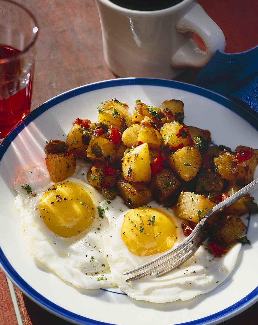 Kartoffelpfanne mit Paprika, Kräutern und zwei Spiegeleiern