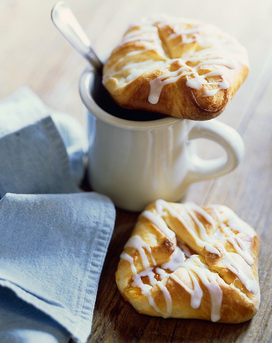 Two Glazed Danish Pastries with a Cup of Coffee