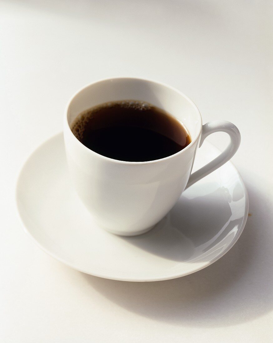 White Cup of Coffee on a White Saucer on a White Background