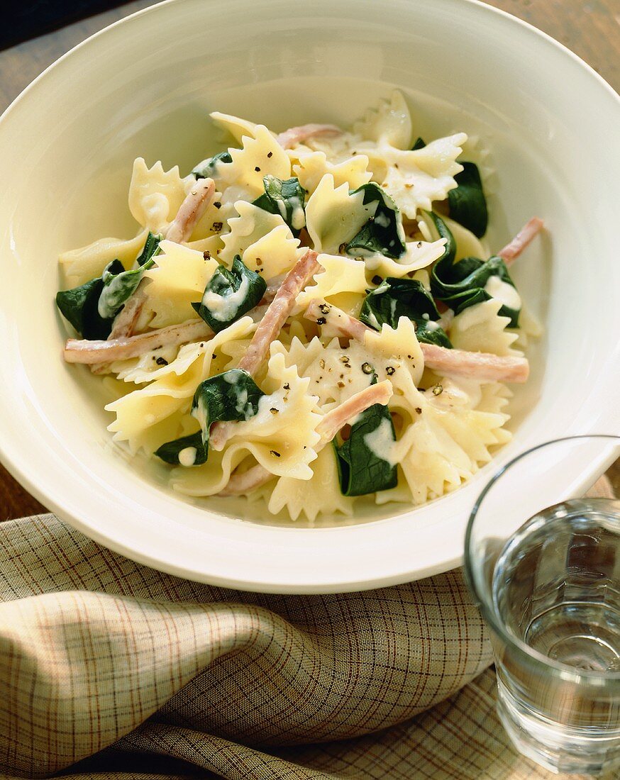Farfalle with Spinach and Ham in a Cream Sauce in a White Bowl