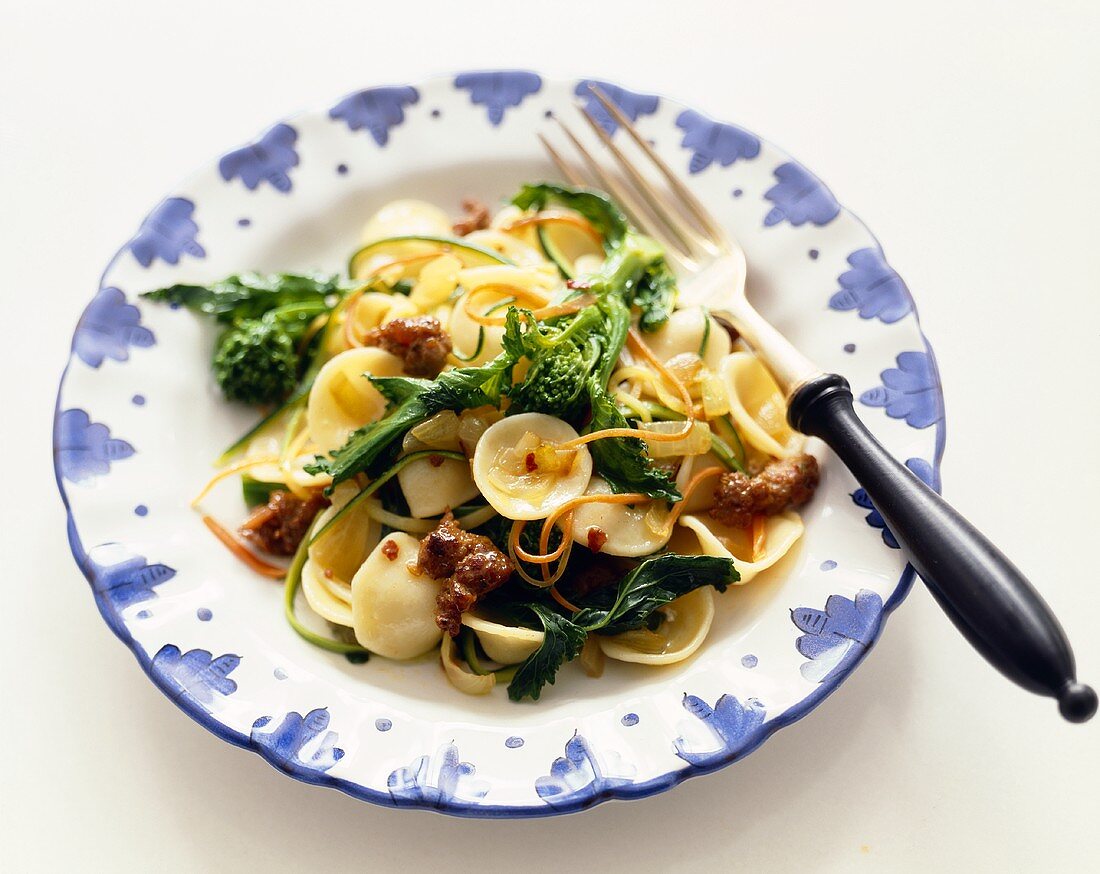 Orrecchietti Pasta with Sausage and Broccoli Rabe on a Plate with Fork on a White Background