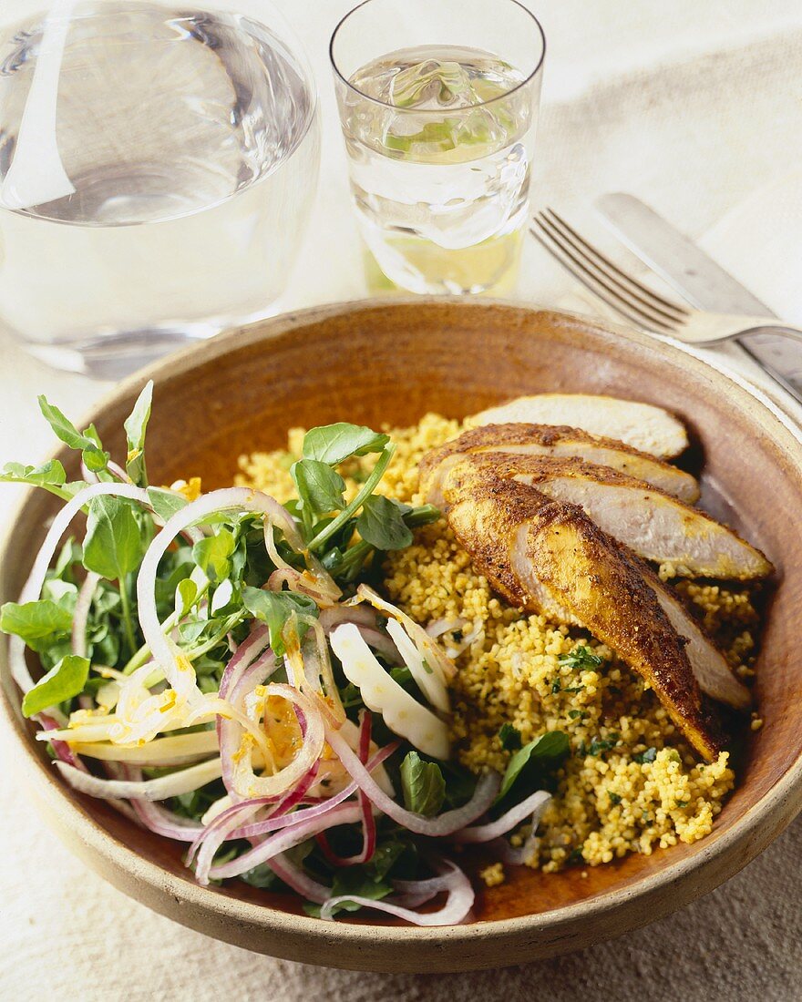 Sliced Spicy Rubbed Chicken Breast with Couscous and Salad in a Wooden Bowl