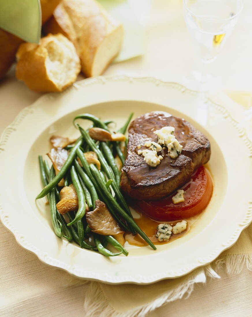 Grilled Steak Topped with Blue Cheese Served with Green Beans and Mushrooms on a Plate