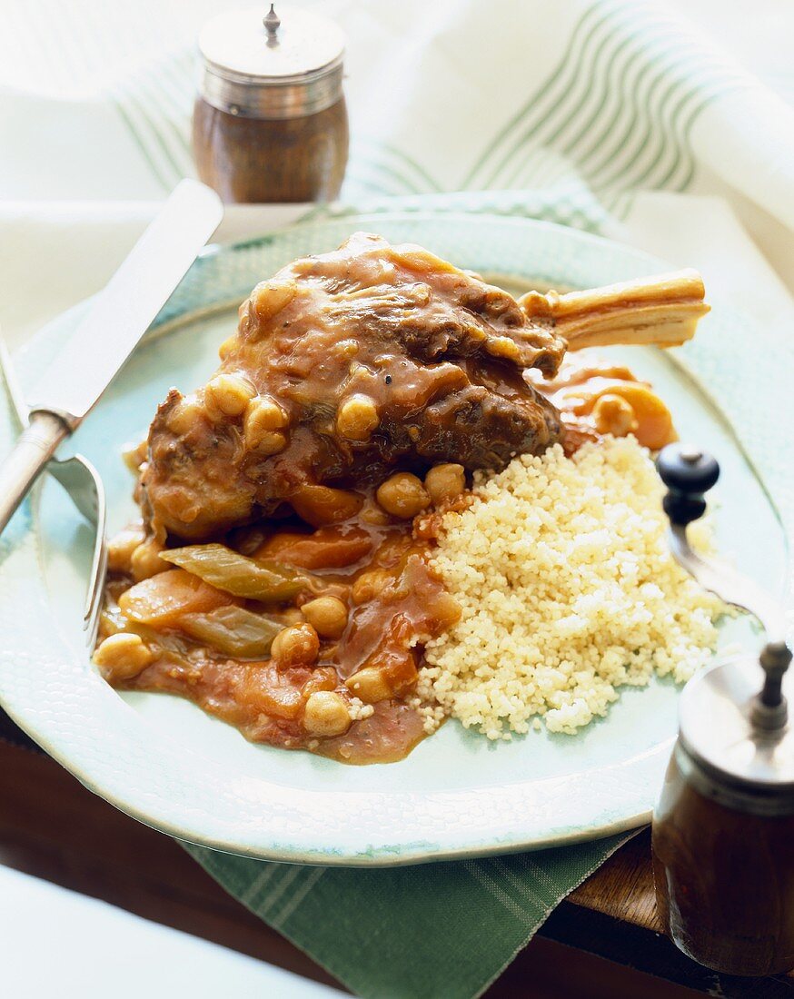 Stewed Veal Shank with Couscous on a Plate with Knife and Fork