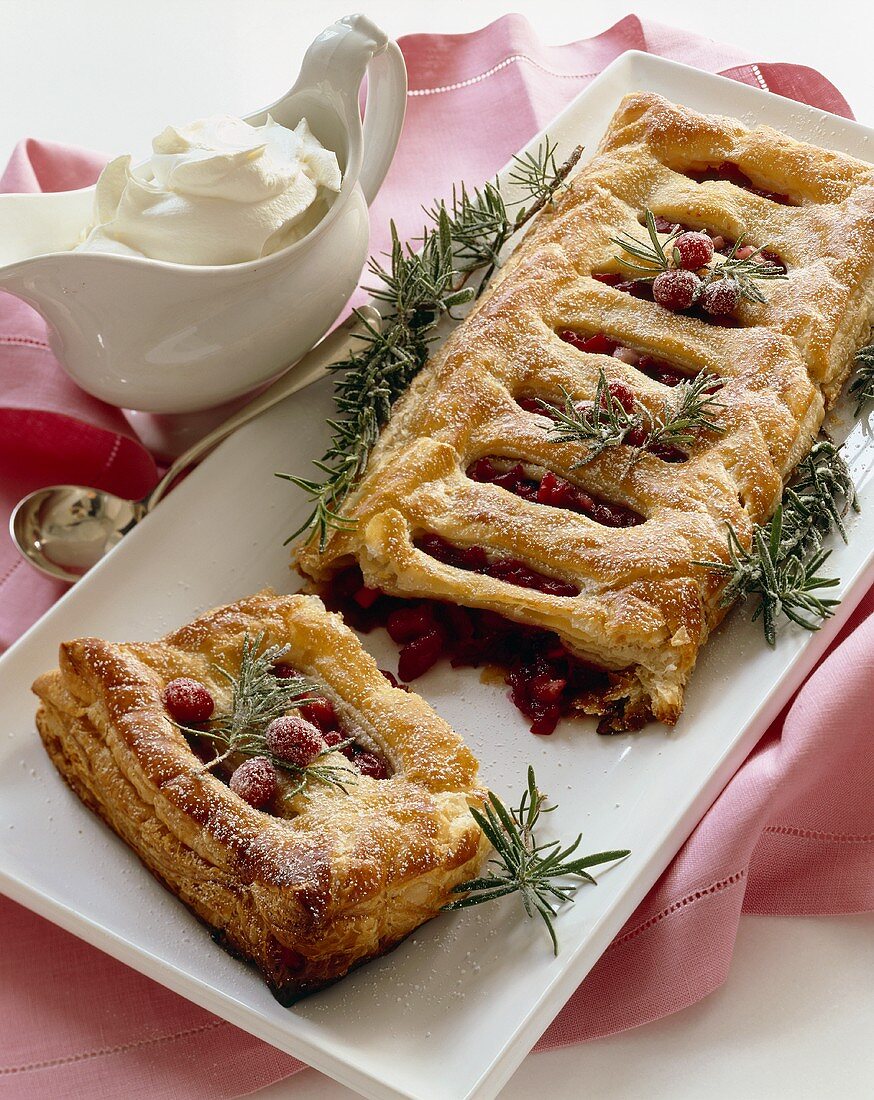 Cranberry Strudel Broken on a Platter; Pitcher of Whipped Cream