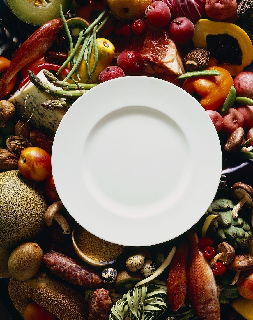 Empty White Plate on a Variety of Fresh Ingredients; Overhead