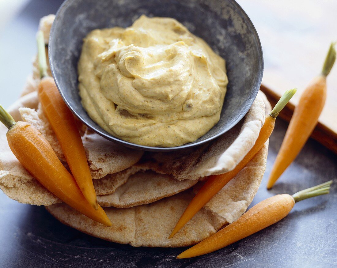 Hummus in Schälchen, dazu Pitabrot & Karotten