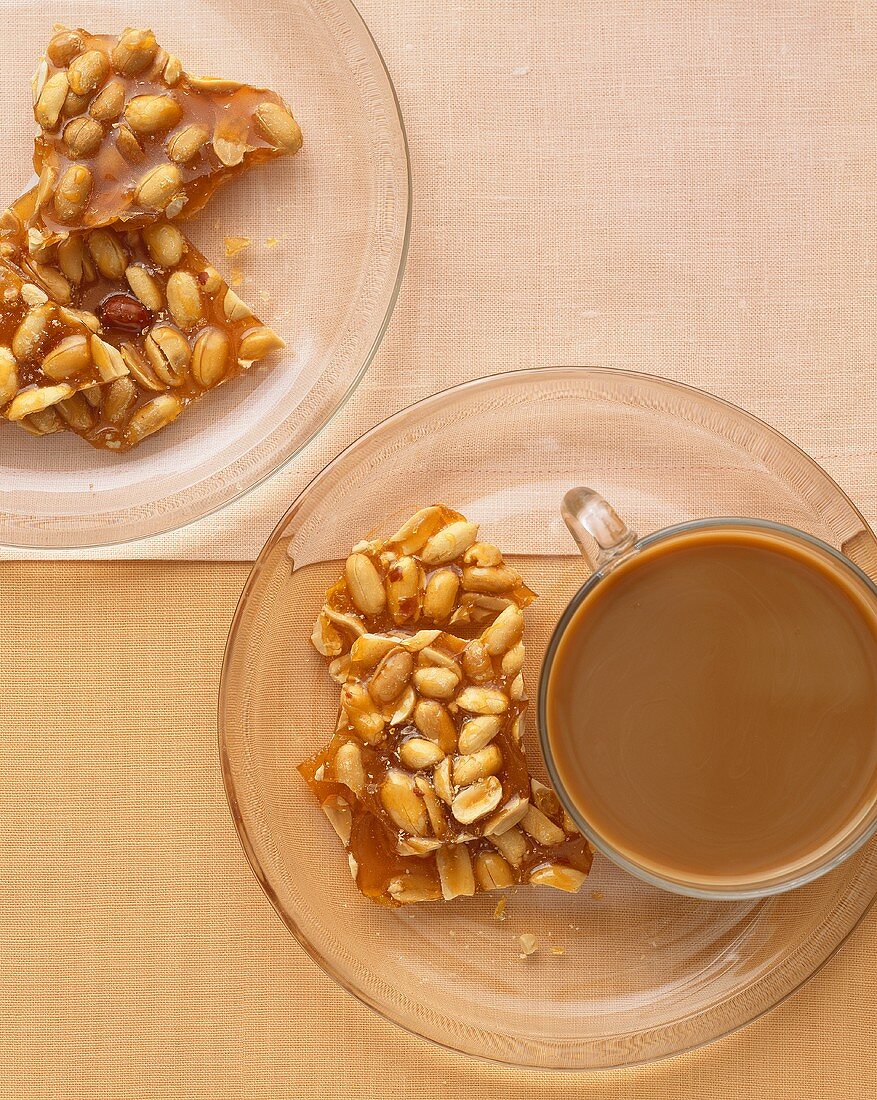Erdnuss-Brittle mit einer Tasse Kaffee