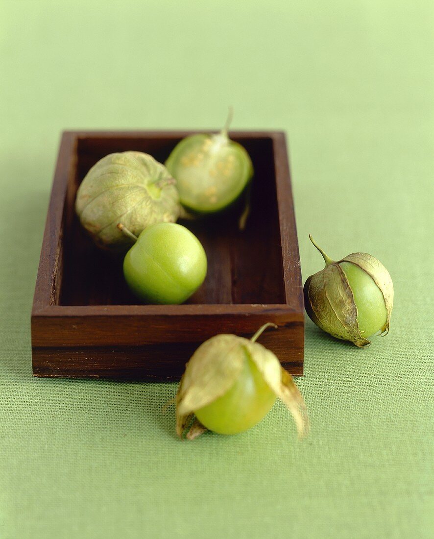 Fresh Tomatillos; In and Beside a Wooden Box