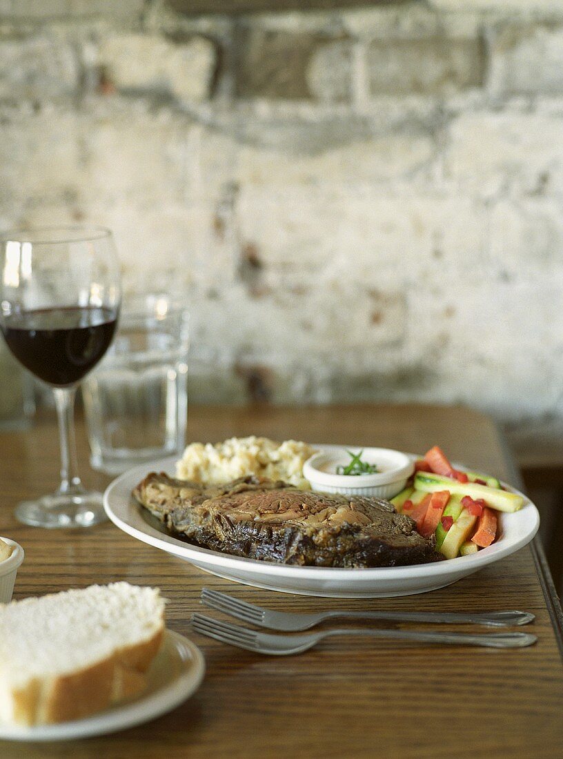 Prime-Rib Steak mit Beilagen auf rustikalem Tisch