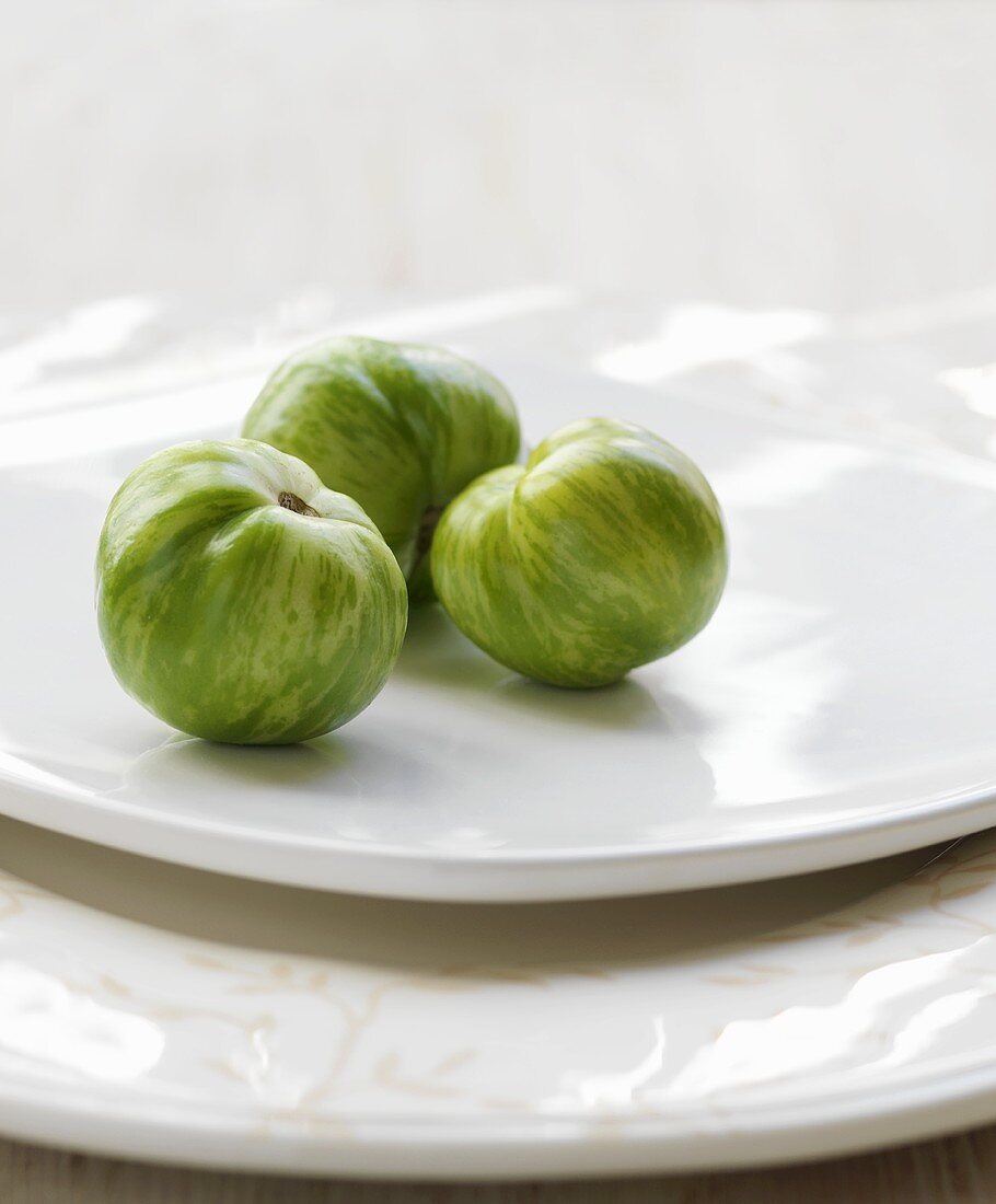 Three Green Heirloom Tomatoes on a White Plate