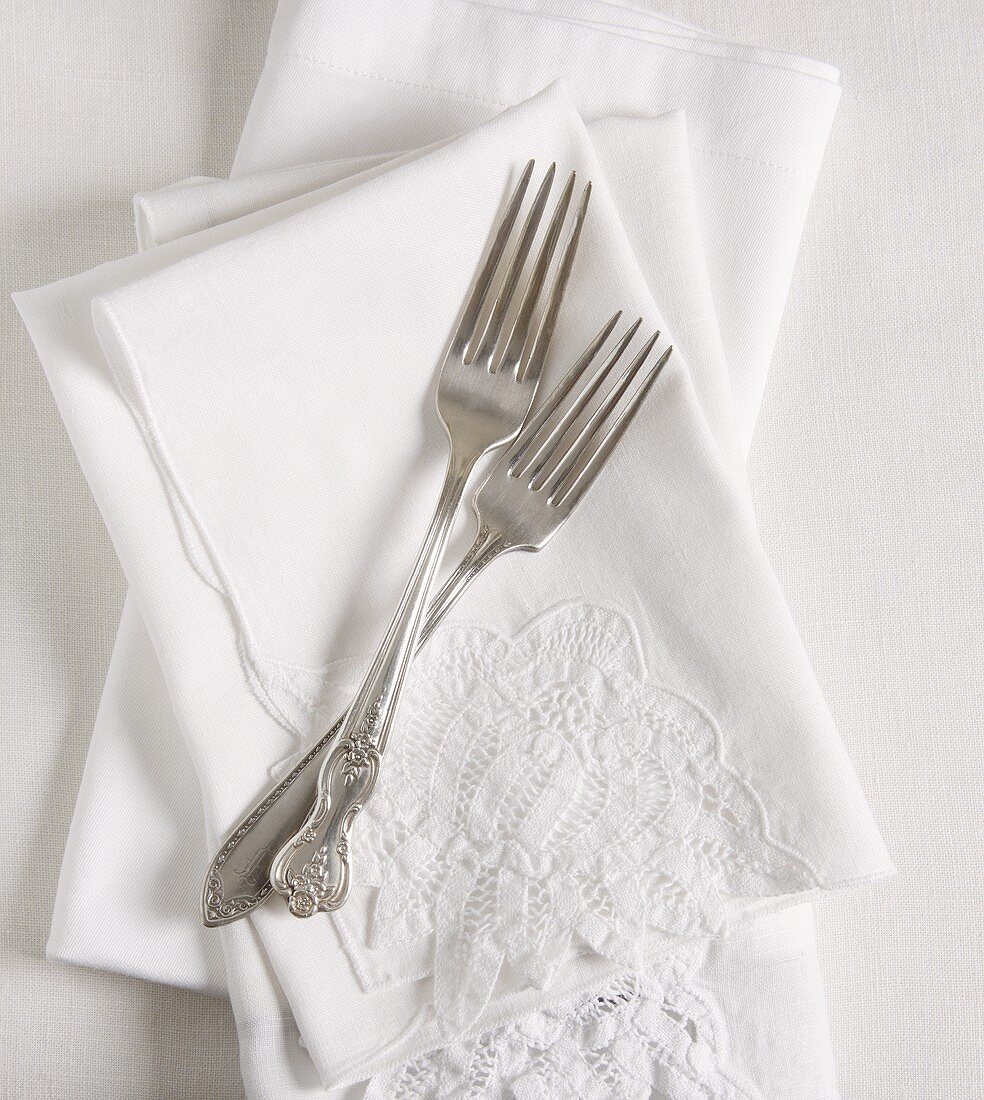Two Antique Forks on White Wedding Napkins