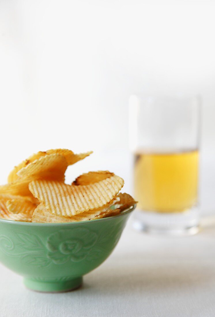 Bowl of Ridged Potato Chips and Glass of Beer