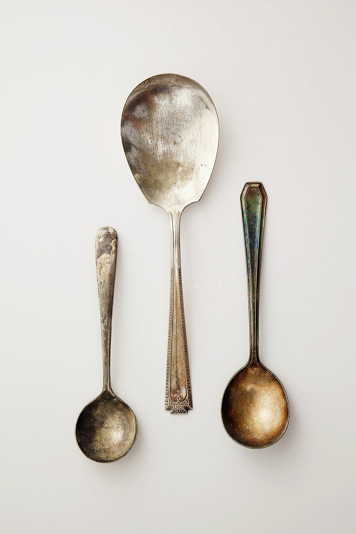 Three Antique Spoons on a White Background