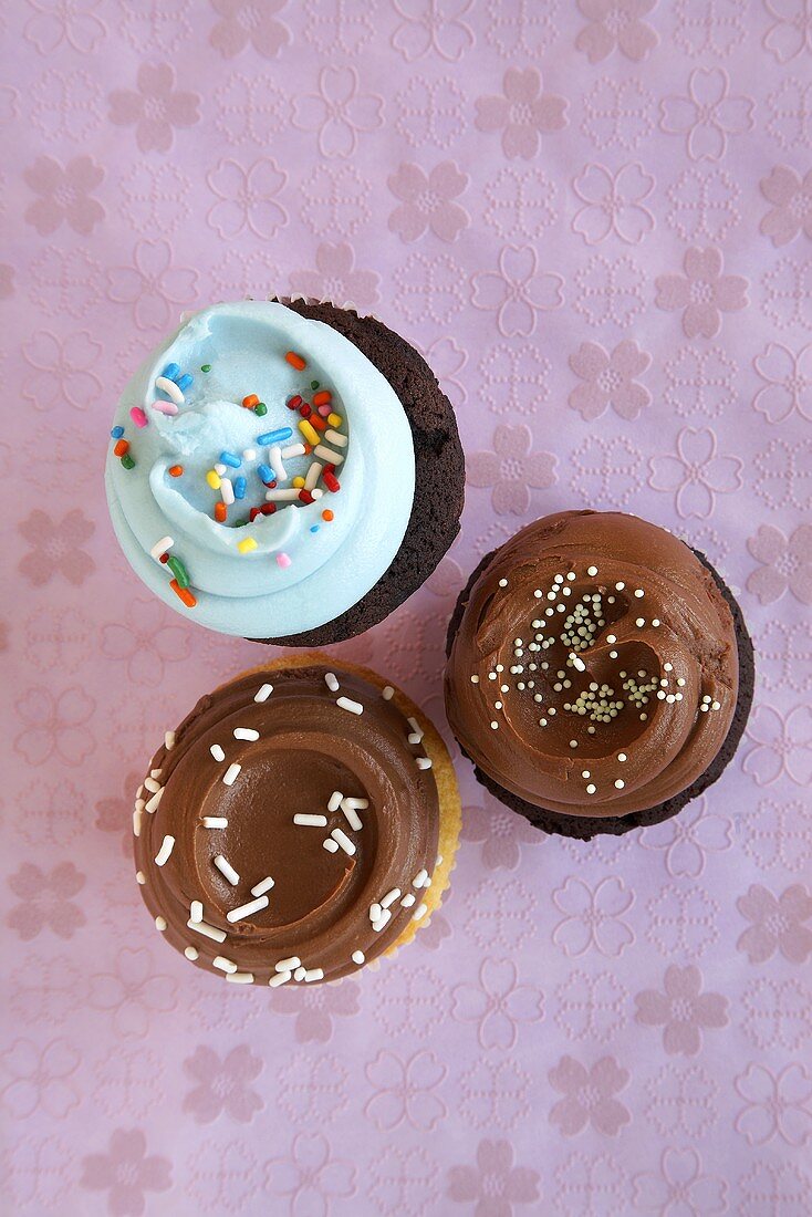 Three Assorted Cupcakes with Frosting and Sprinkles; From Above