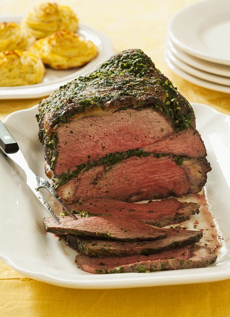 Herb Encrusted Roast Beef Partially Sliced on a Platter