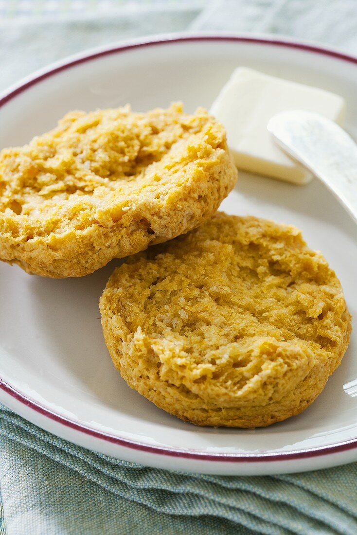 Süsskartoffel-Biscuit, halbiert, mit Butter auf Teller