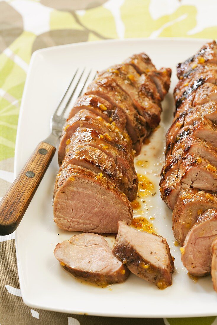 Two Sliced Orange Glazed Pork Tenderloins on Platter; Grilled