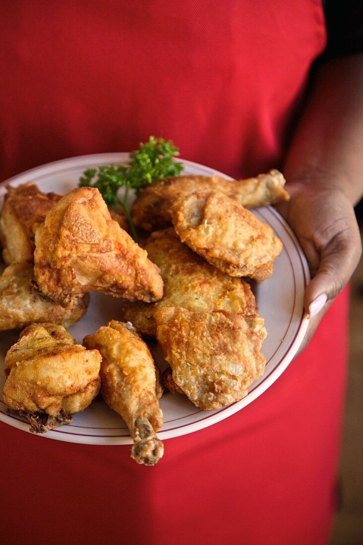 Person Holding a Plate of Organic Fried Chicken
