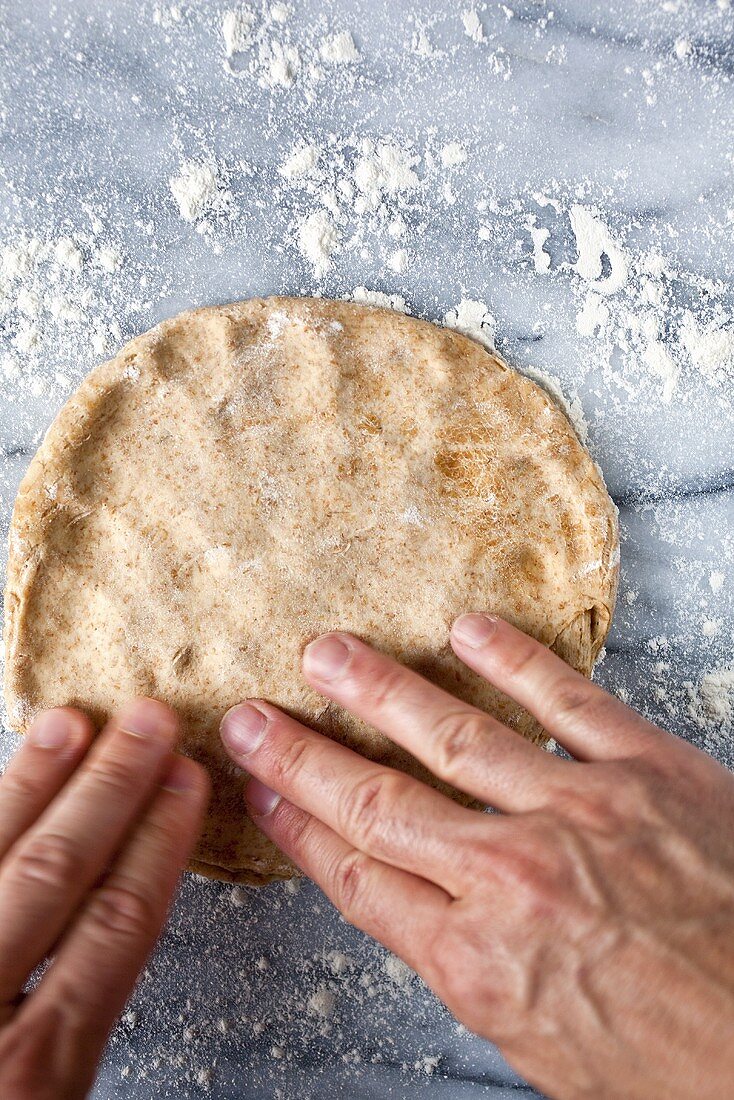 Hands Flattening Olive Oil Dough