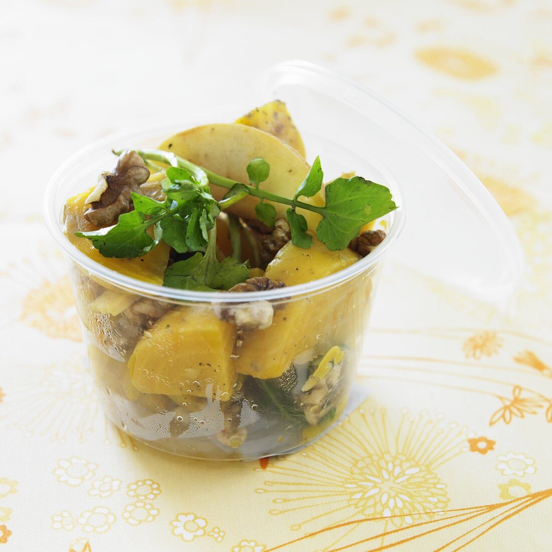 Golden Beet Salad with Walnuts and Greens in a Plastic Container