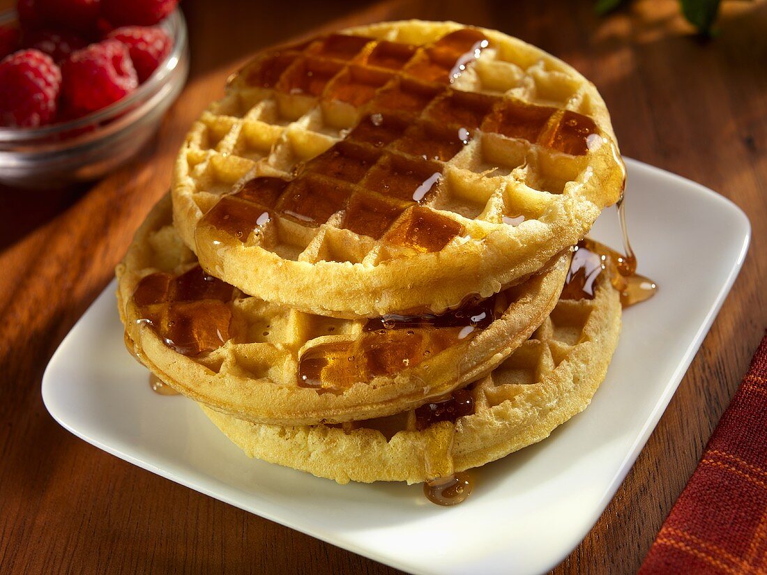 Stack of Three Waffles with Maple Syrup; Raspberries