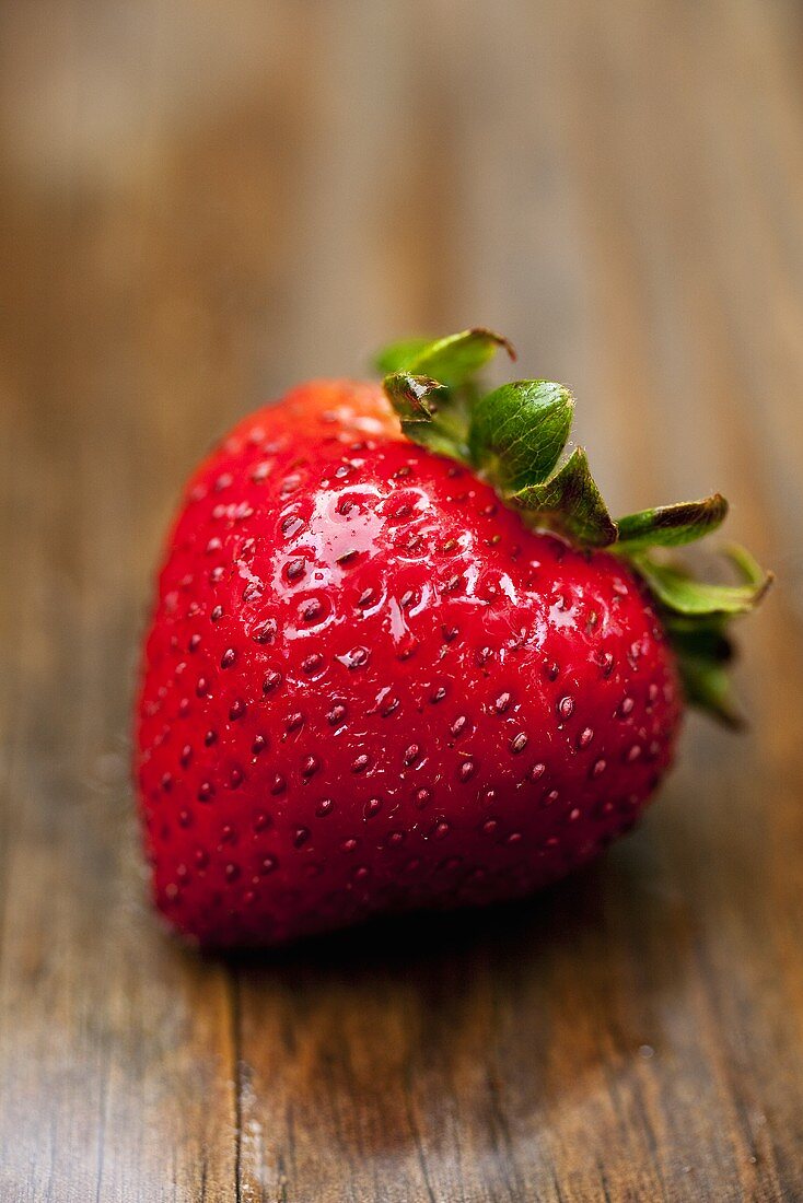 A strawberry on wooden background