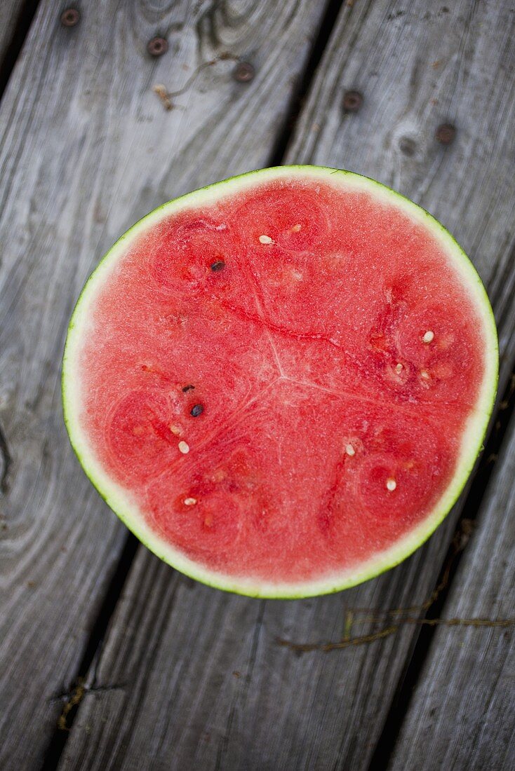 Halbe Wassermelone auf Holzuntergrund