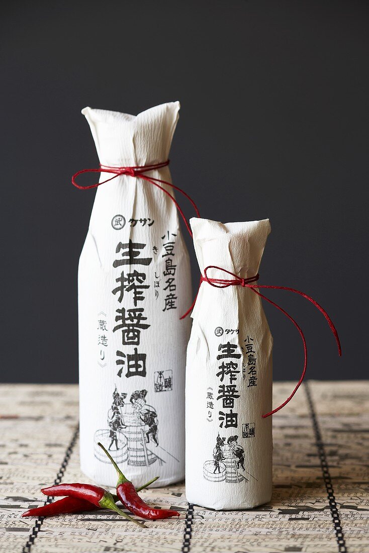 Two Bottles of Asian Sauce Wrapped in Paper Tied with Red String