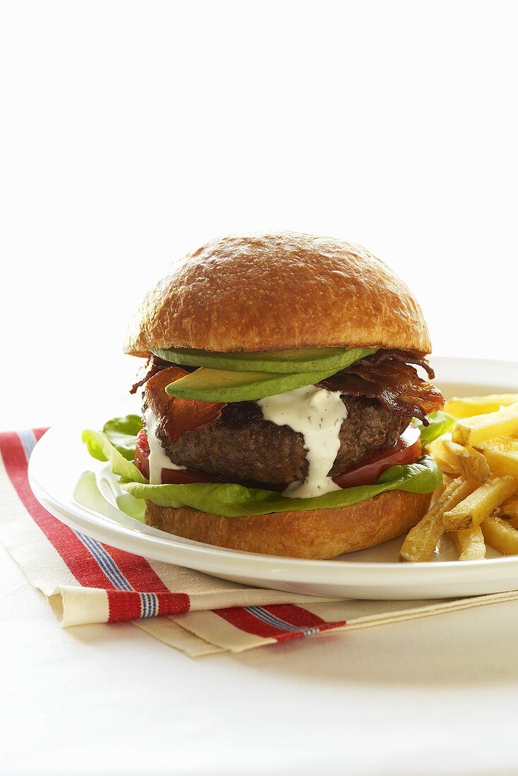 Ein Hamburger mit Avocado, Speck und Pommes Frites