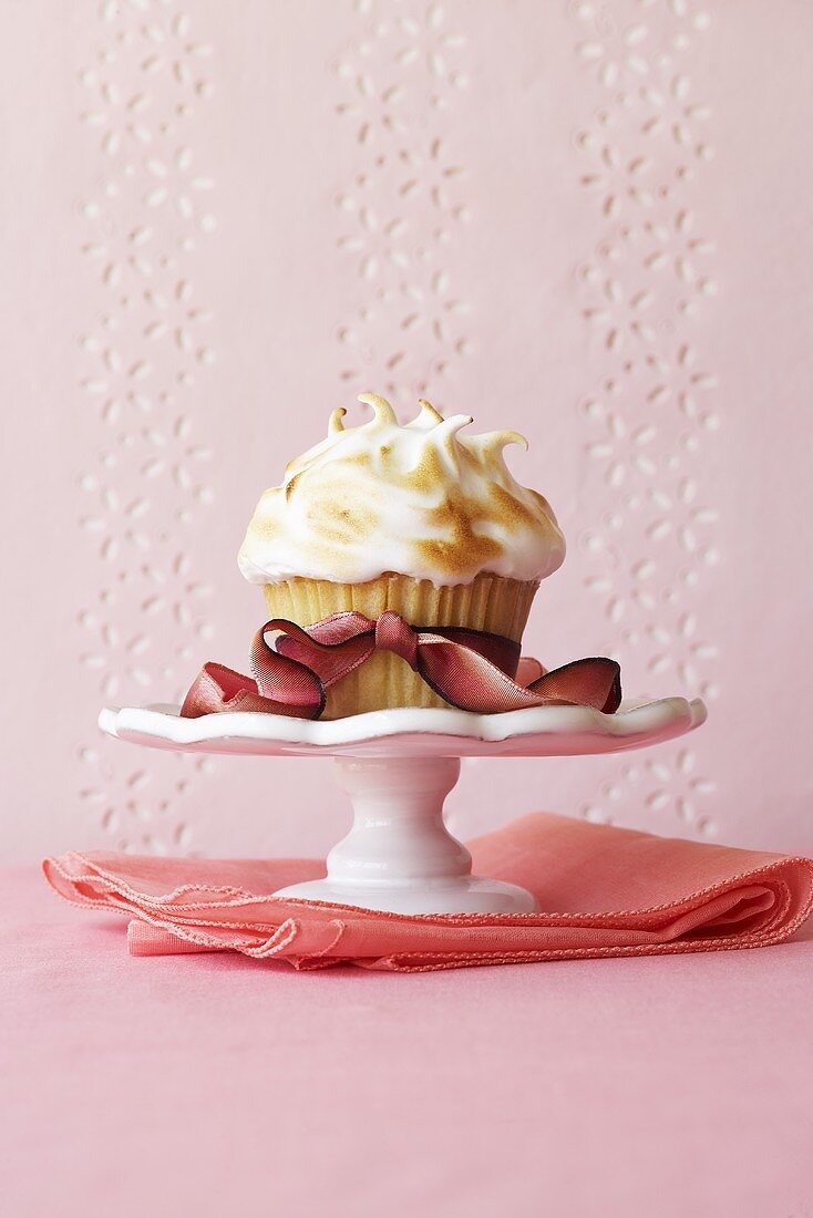 Cupcake auf kleinem Kuchenständer mit einer Schleife