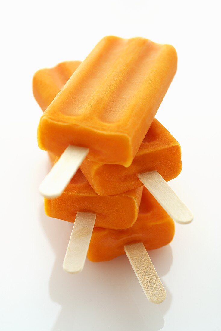 Four Orange Popsicles Stacked; White Background