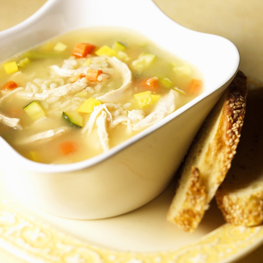 Bowl of Chicken and Rice Soup; Slices of Bread