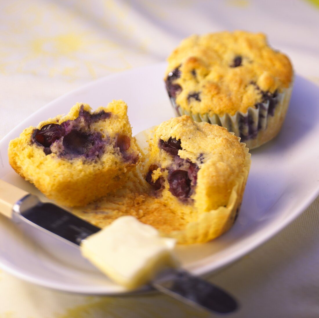 Blueberry Corn Muffins; One Halved on Plate; Knife and Butter
