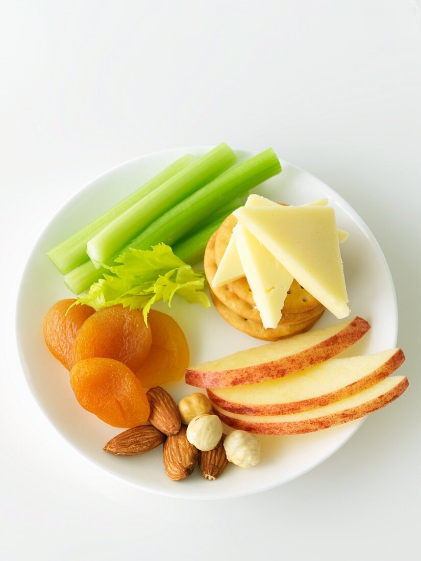 Plate with Crackers, Cheese, Apple, Nuts, Dried Apricots and Celery Sticks