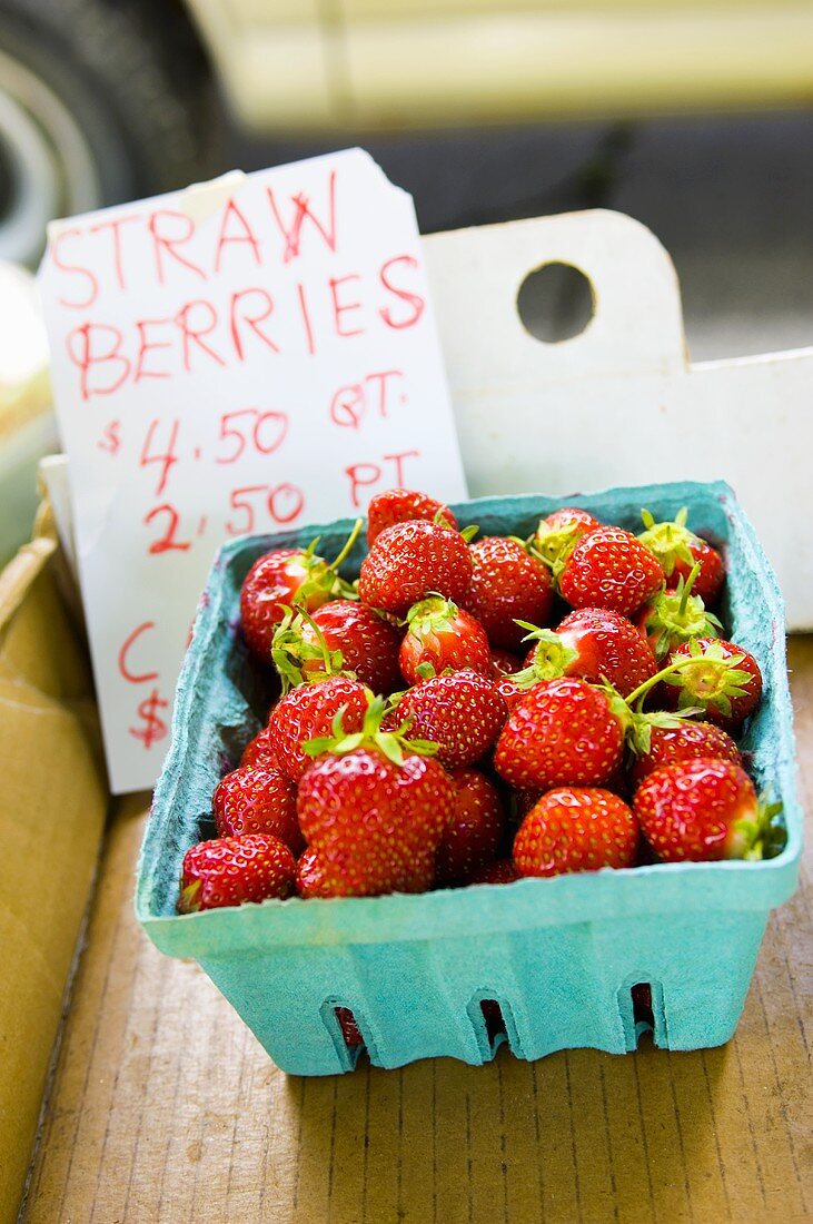 Schale mit Erdbeeren auf Marktstand mit Preisschild