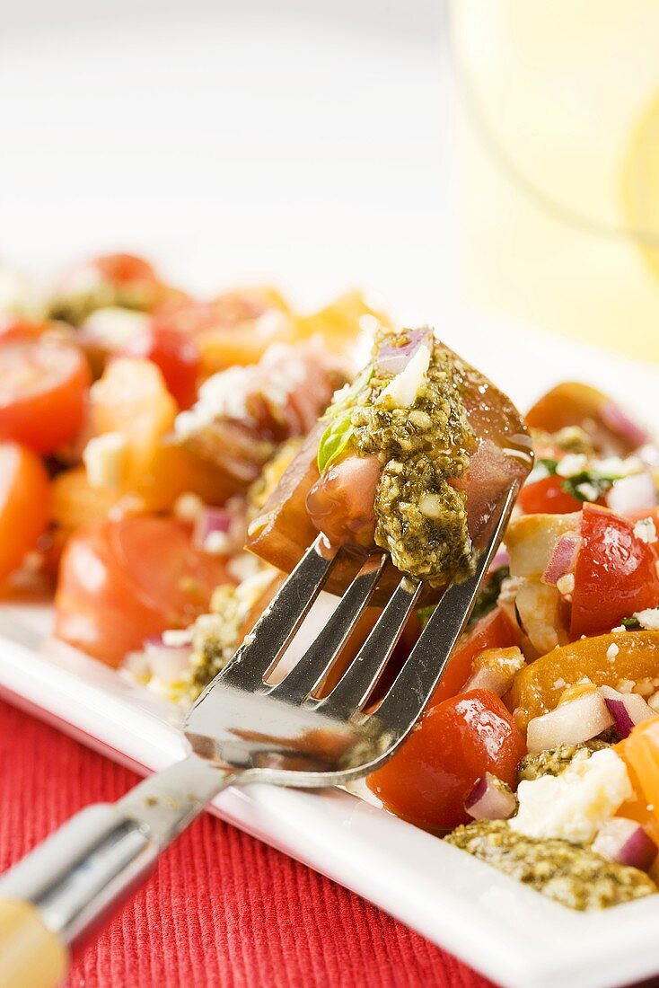 Heirloom Tomato Salad with Pesto Sauce; Fork Stabbing Tomato