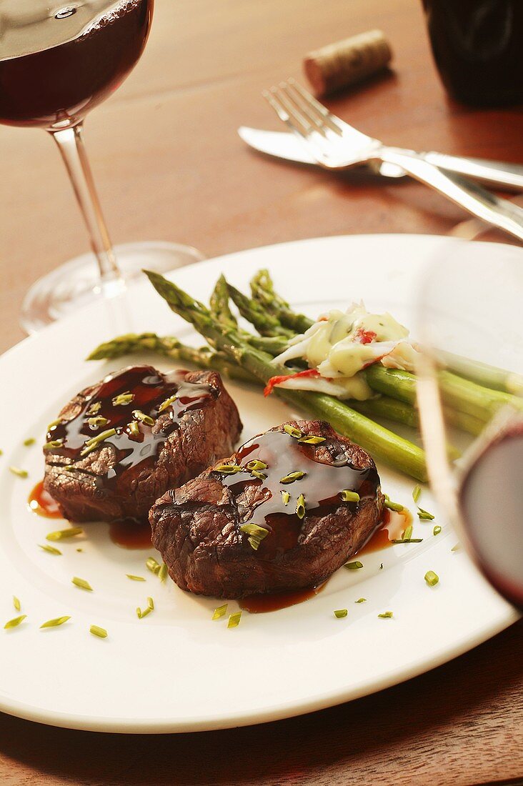 Two Filet Mignons on a Plate with Asparagus; Red Wine